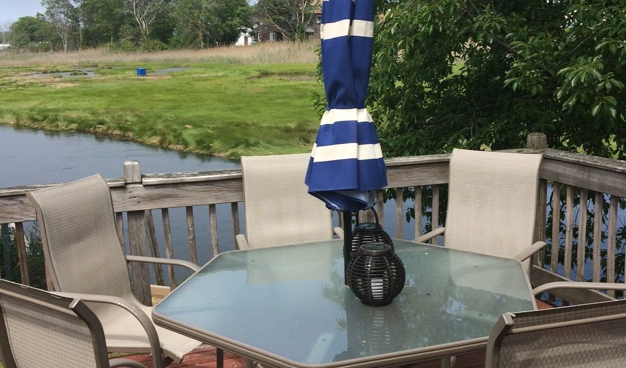 a table and chairs with an umbrella on a deck.