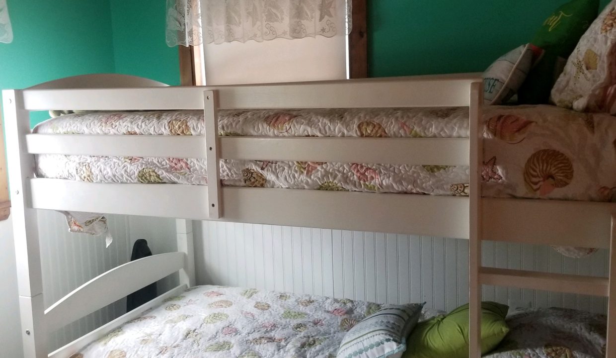 Two bunk beds in a room with green walls.