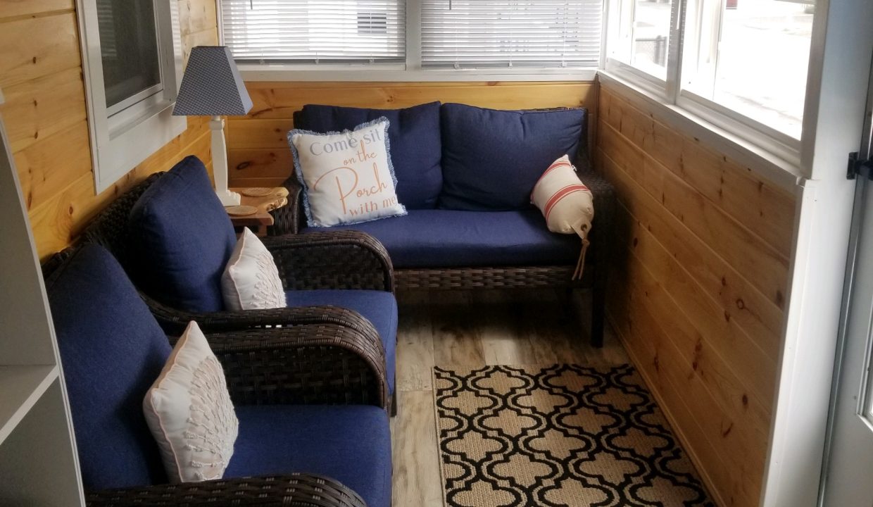 A living room with blue couches and a window.