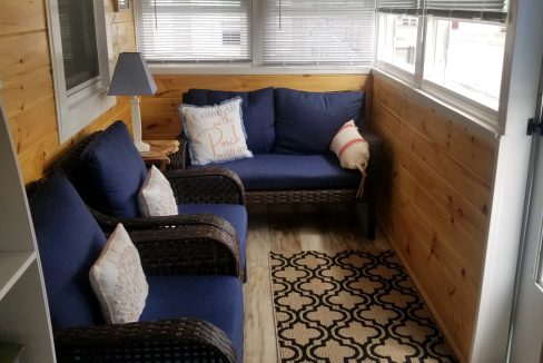 A living room with blue couches and a window.