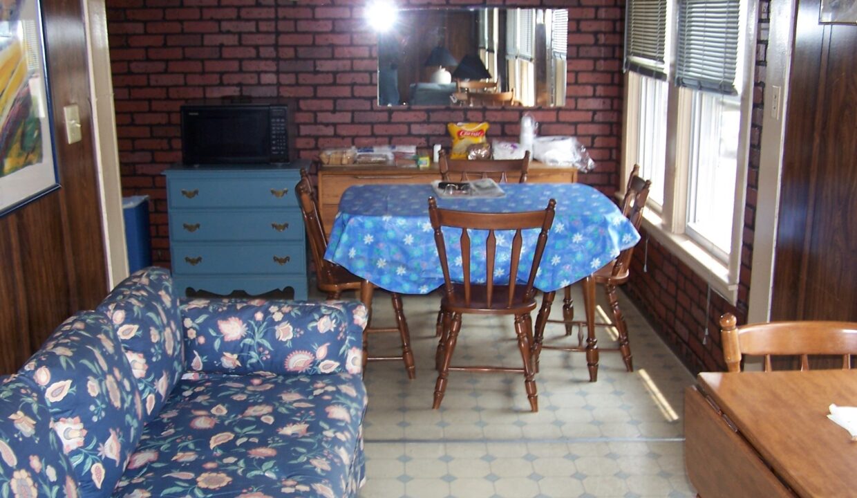 a living room filled with furniture and a brick wall.