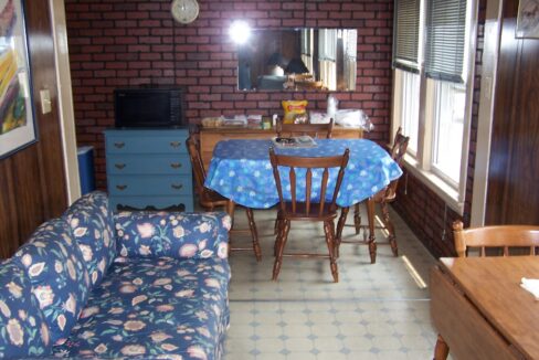 a living room filled with furniture and a brick wall.