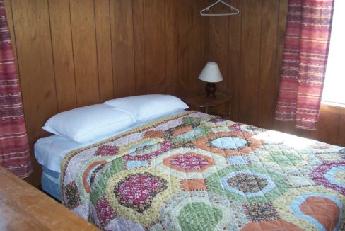 a bed with a quilt on it in a room.