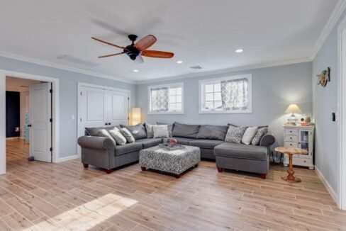 a living room filled with furniture and a ceiling fan.