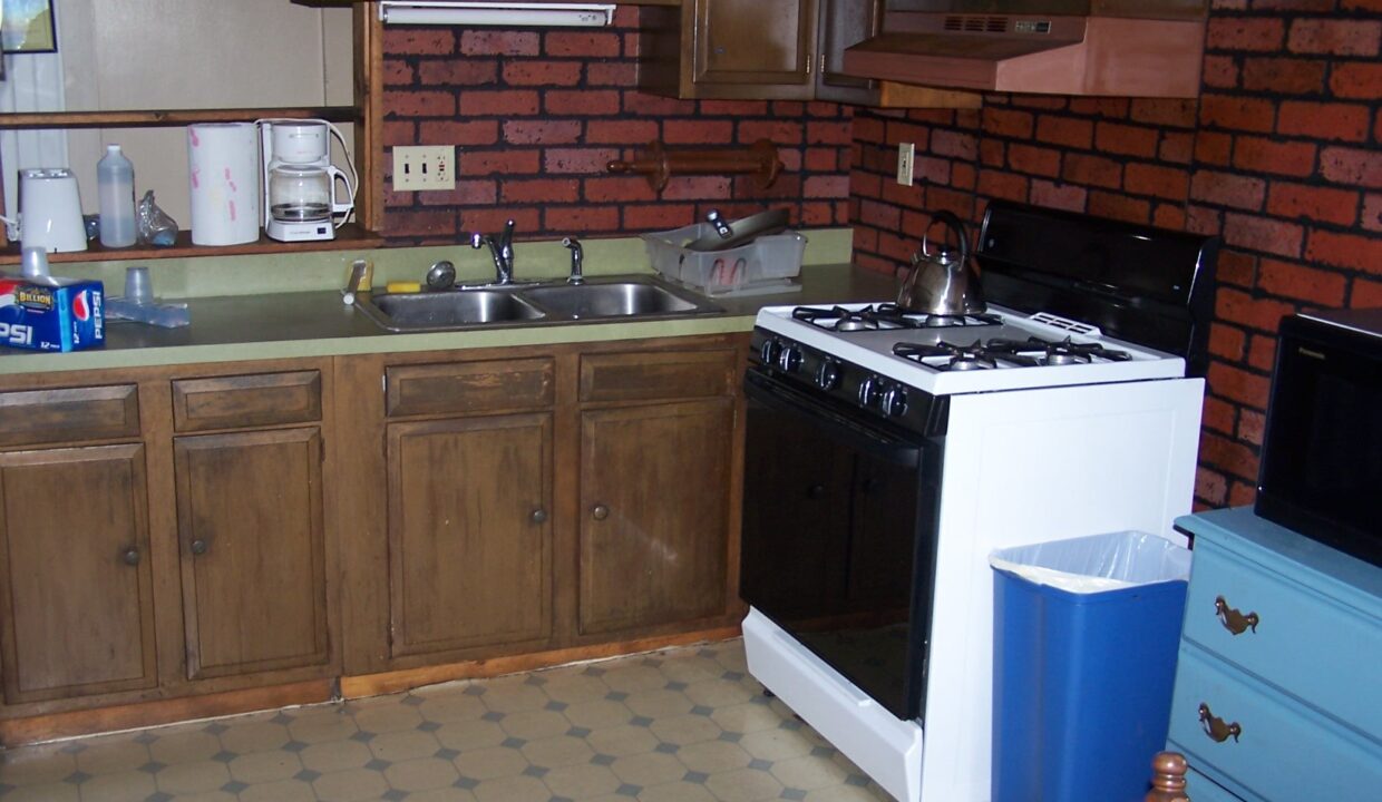 a kitchen with a stove top oven next to a sink.