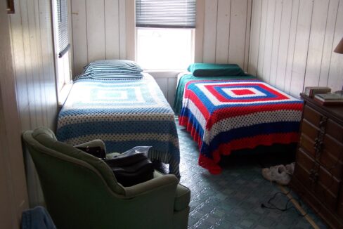 a bedroom with two beds and a chair.