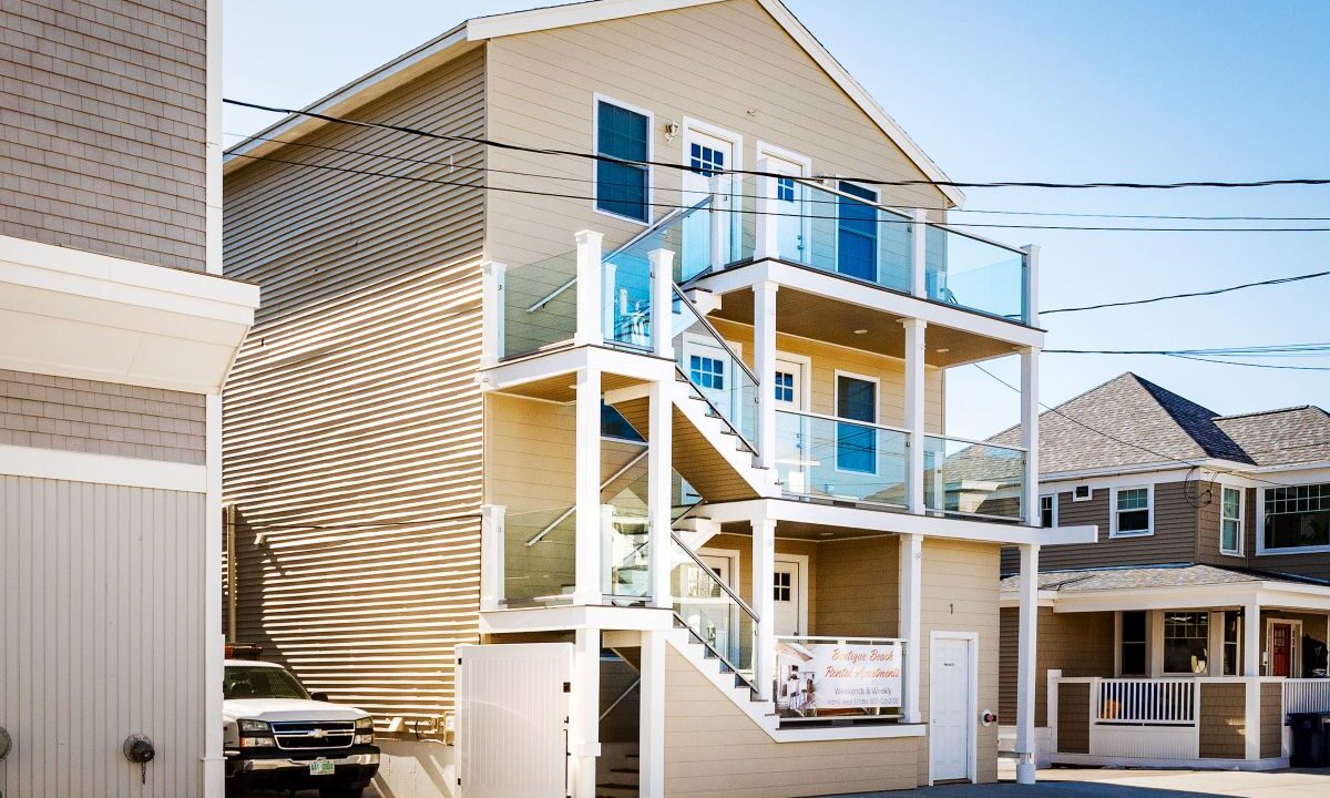 a two story house with a car parked in front of it.