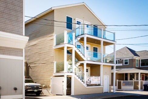 a two story house with a car parked in front of it.