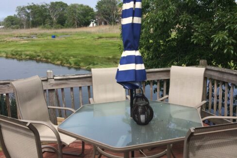 a table and chairs with an umbrella on a deck.