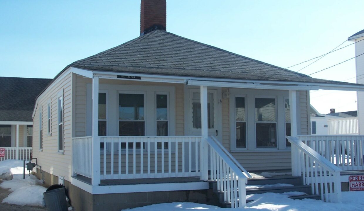 a small house with a porch and a porch covered in snow.