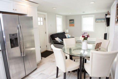 a kitchen with a refrigerator and a table with chairs.