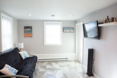 a living room with a black couch and a flat screen tv.