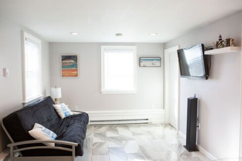 a living room with a blue couch and a flat screen tv.