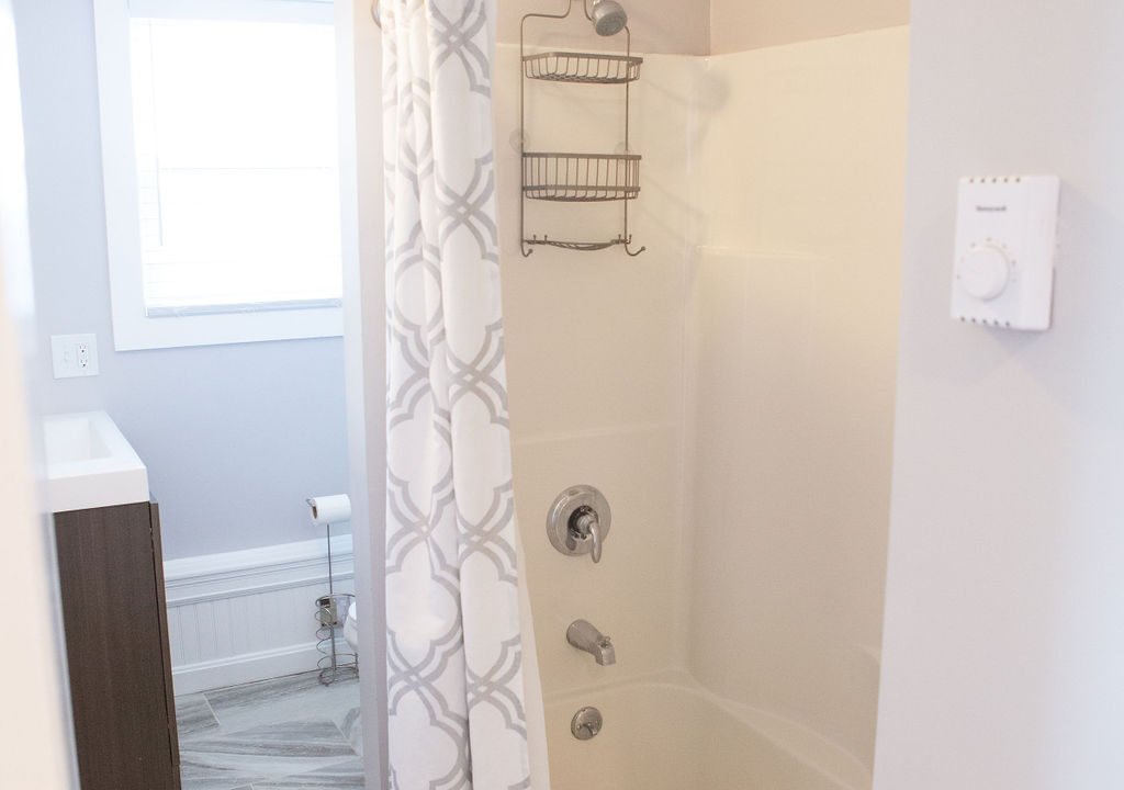 a bathroom with a shower, toilet and bathtub.