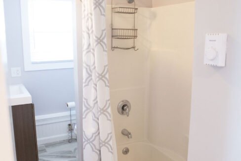 a bathroom with a shower, toilet and bathtub.