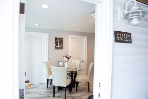 a dining room with a glass table and white chairs.