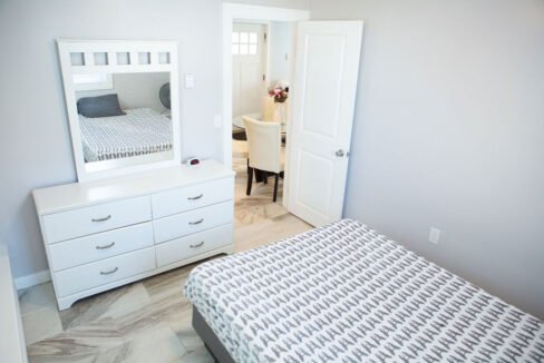 a bedroom with a bed, dresser and mirror.