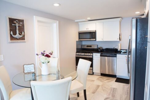 a kitchen with a glass table and white chairs.