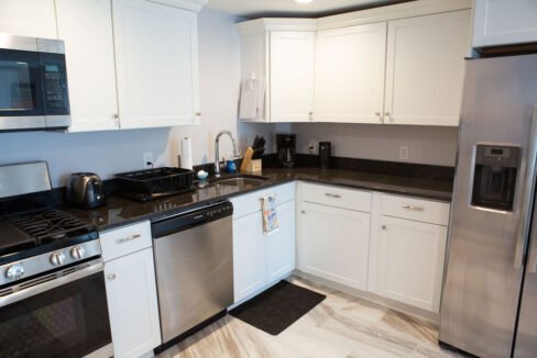 a kitchen with stainless steel appliances and white cabinets.