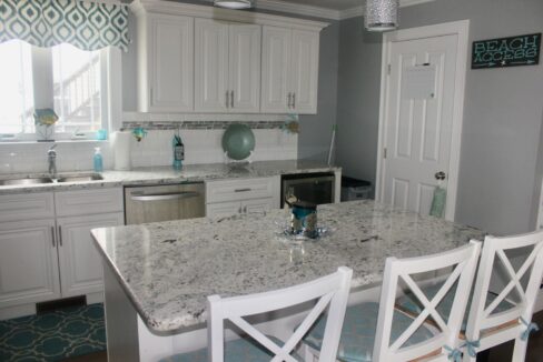 a kitchen with a marble counter top and white cabinets.