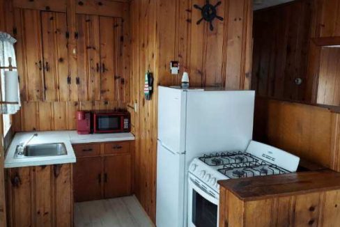 a kitchen with wood paneling and white appliances.