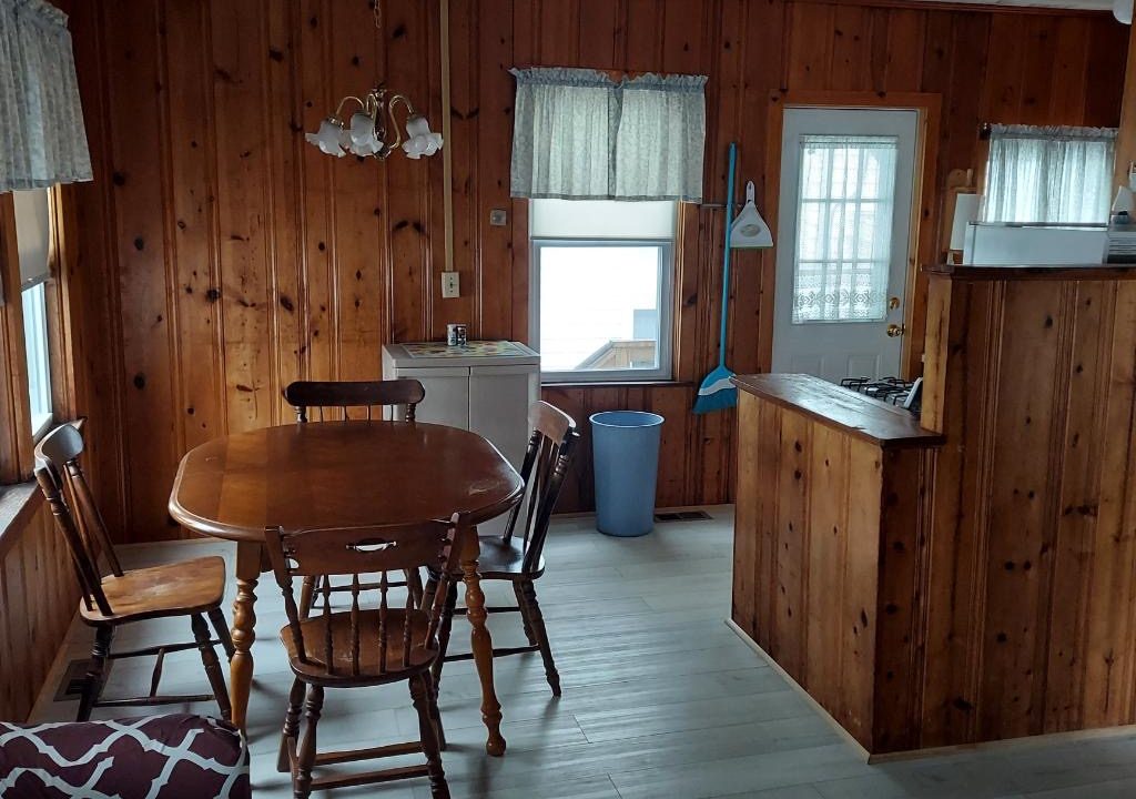 a kitchen and dining room with wood paneling.