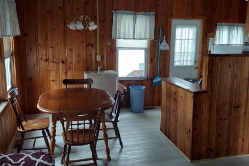 a kitchen and dining room with wood paneling.