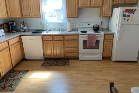 a kitchen with wooden cabinets and white appliances.