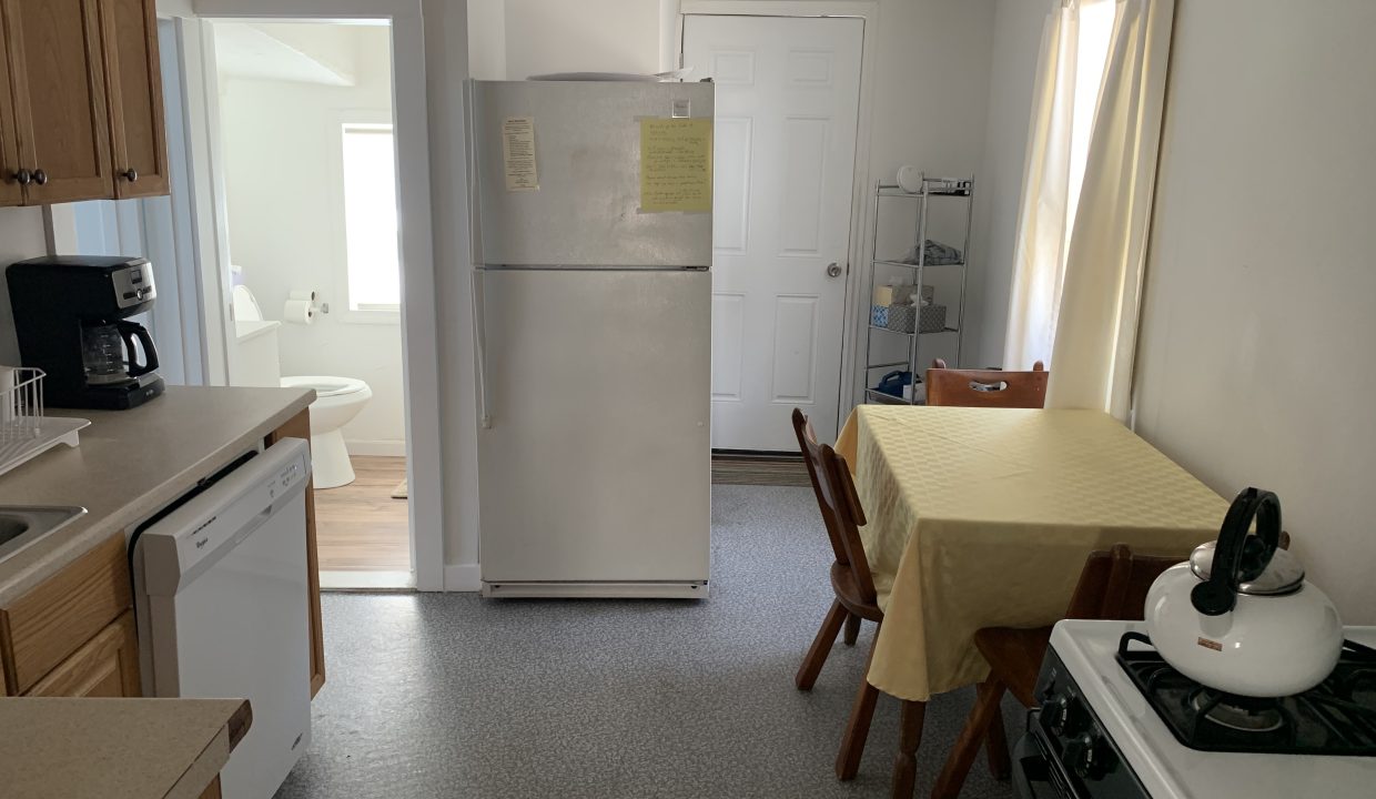 a kitchen with a refrigerator and a table.