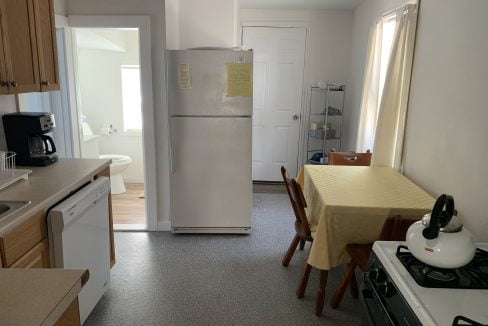a kitchen with a refrigerator and a table.