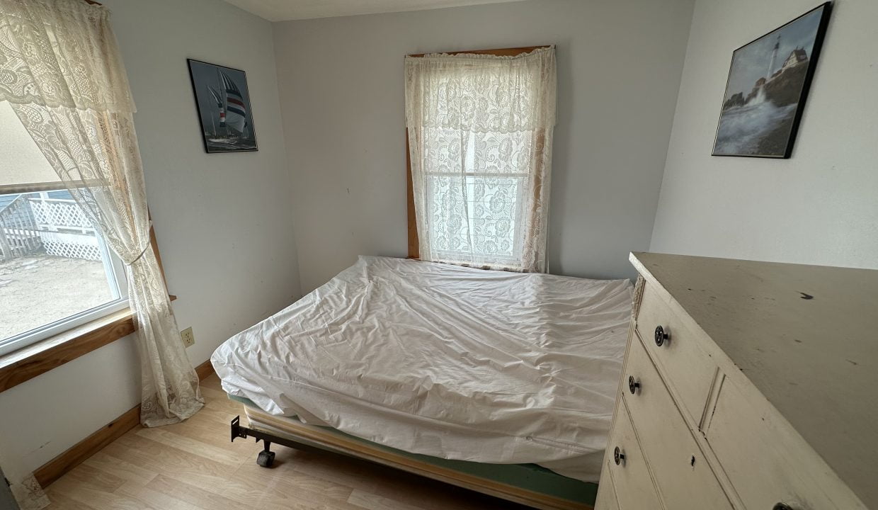 a bed sitting in a bedroom next to a window.