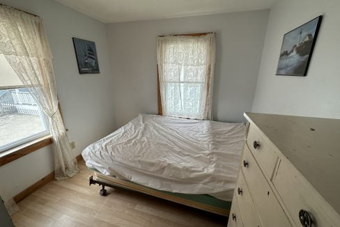 a bed sitting in a bedroom next to a window.