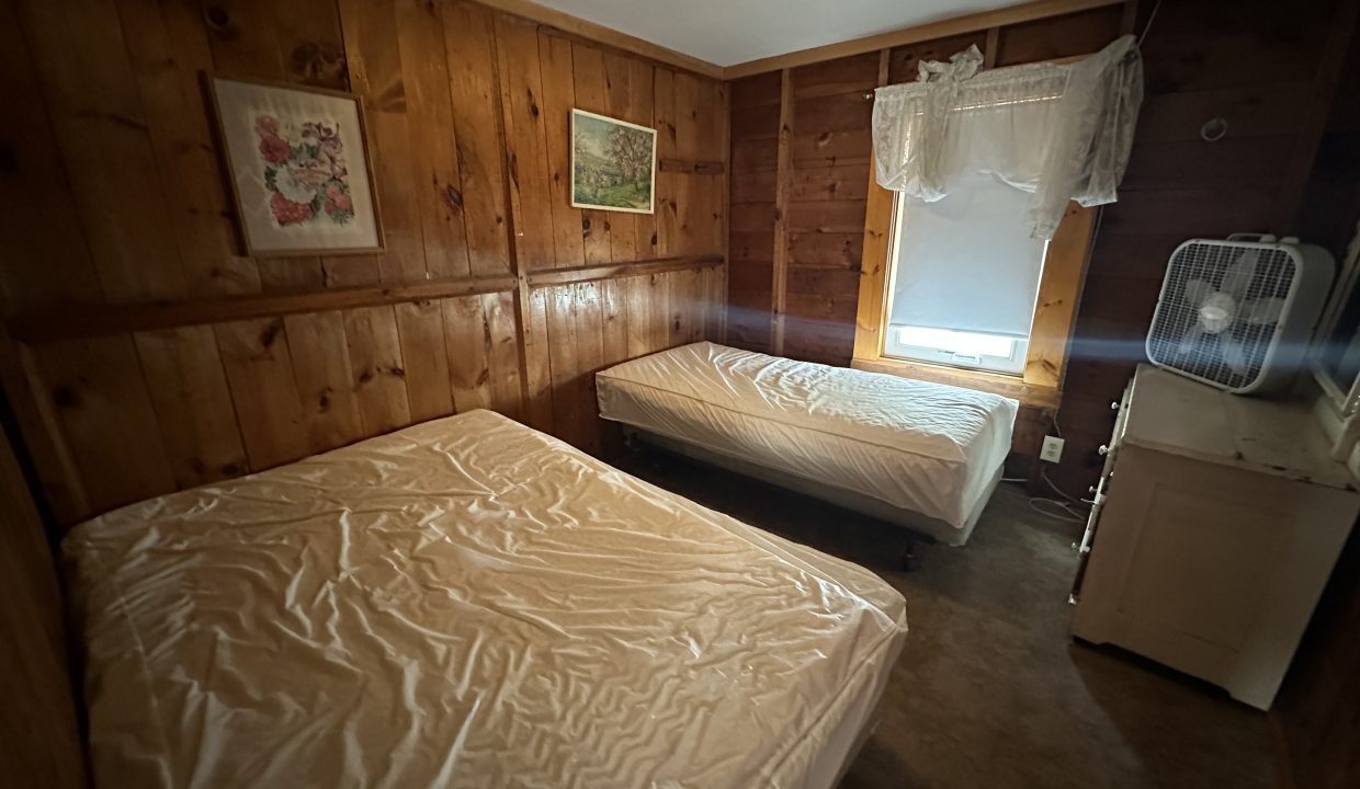 a bed room with two beds and a window.