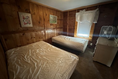 a bed room with two beds and a window.