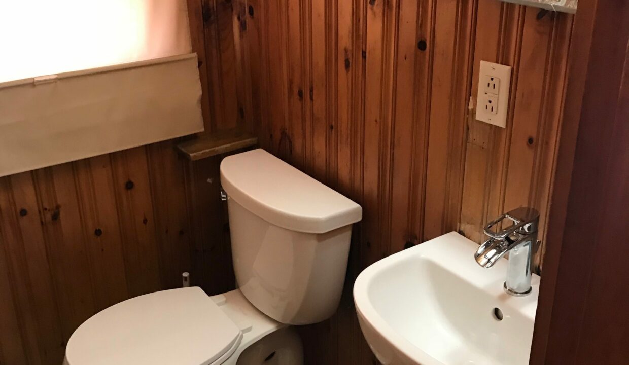 a white toilet sitting next to a white sink.