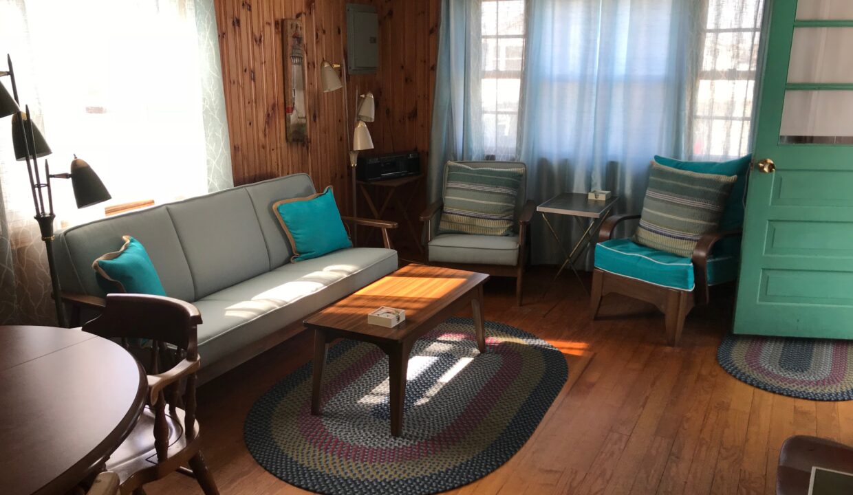 a living room filled with furniture and a wooden floor.