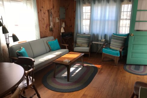 a living room filled with furniture and a wooden floor.