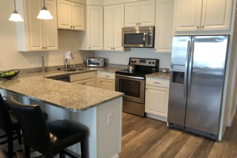 a kitchen with stainless steel appliances and white cabinets.