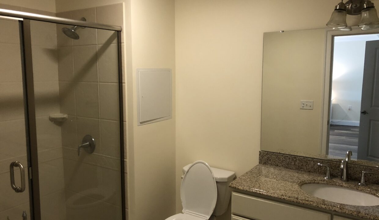 a white toilet sitting next to a walk in shower.