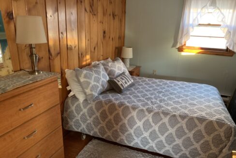 a bedroom with a bed, dresser and mirror.