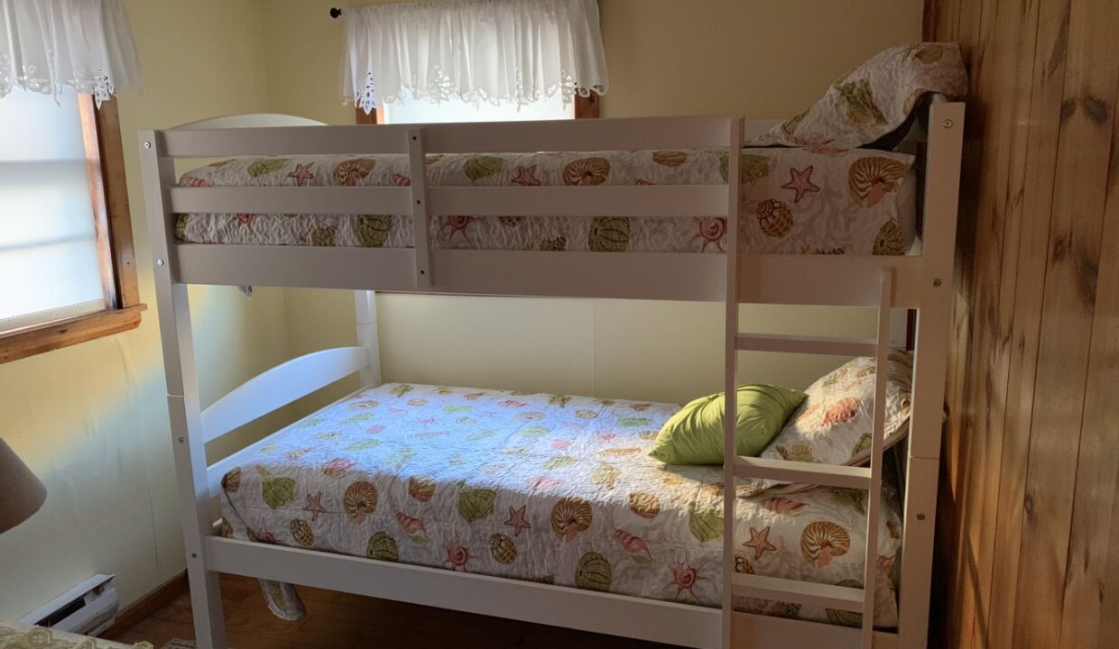 a bedroom with a bunk bed and a window.