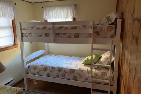 a bedroom with a bunk bed and a window.