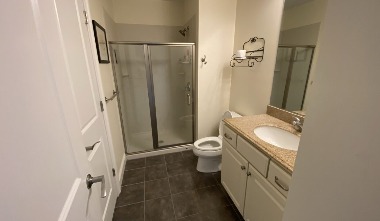 a bathroom with a walk in shower next to a toilet.