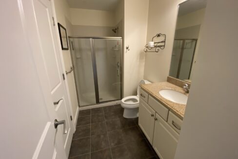 a bathroom with a walk in shower next to a toilet.