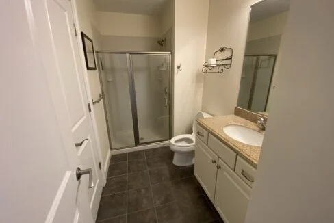 a bathroom with a walk in shower next to a toilet.