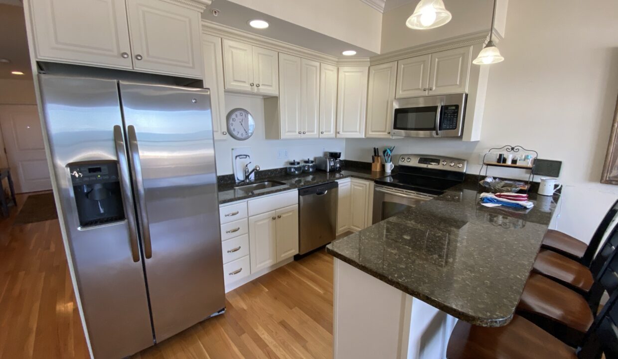 a kitchen with a refrigerator, stove, sink and a microwave.