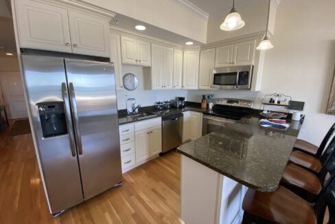 a kitchen with a refrigerator, stove, sink and a microwave.