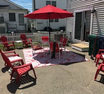 a group of red chairs sitting on top of a patio.