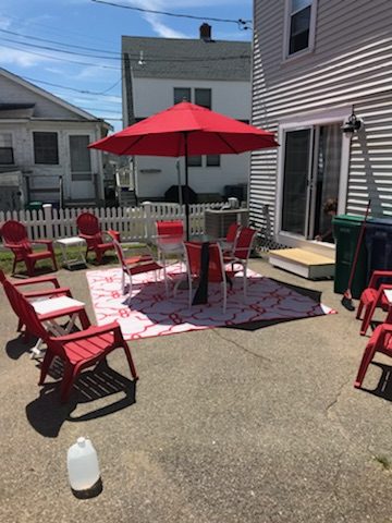 a group of red chairs sitting on top of a patio.