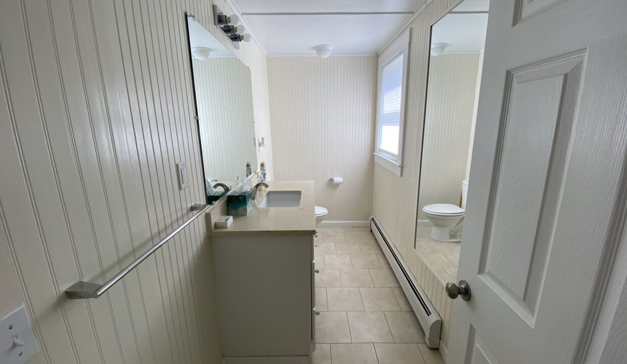 a bathroom with a sink, mirror and toilet.